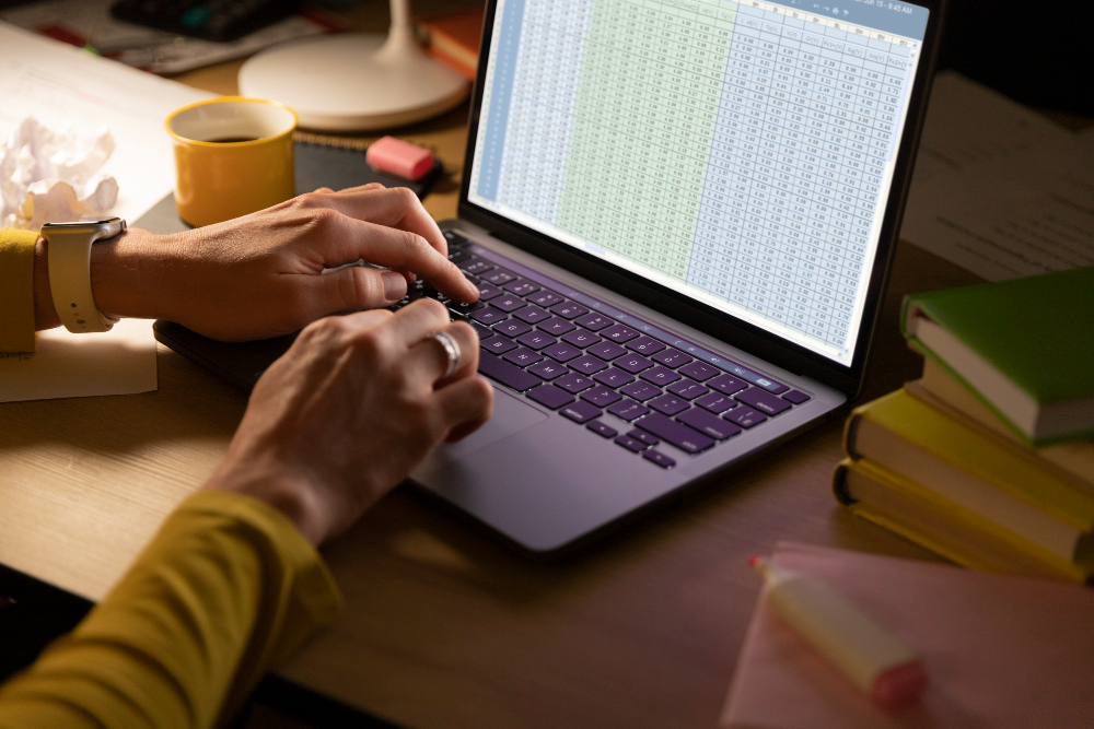 Business owner reviewing a spreadsheet on a laptop while deciding whether to replace Excel with custom software